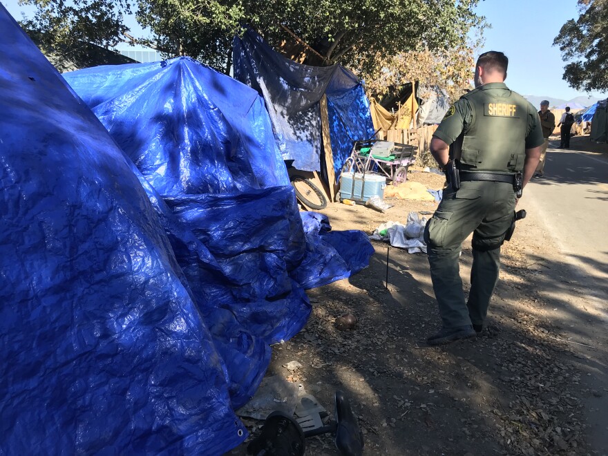 Orange County sheriff's deputies on Monday began going tent to tent along the Santa Ana River telling people the area will be closed and they need to move.