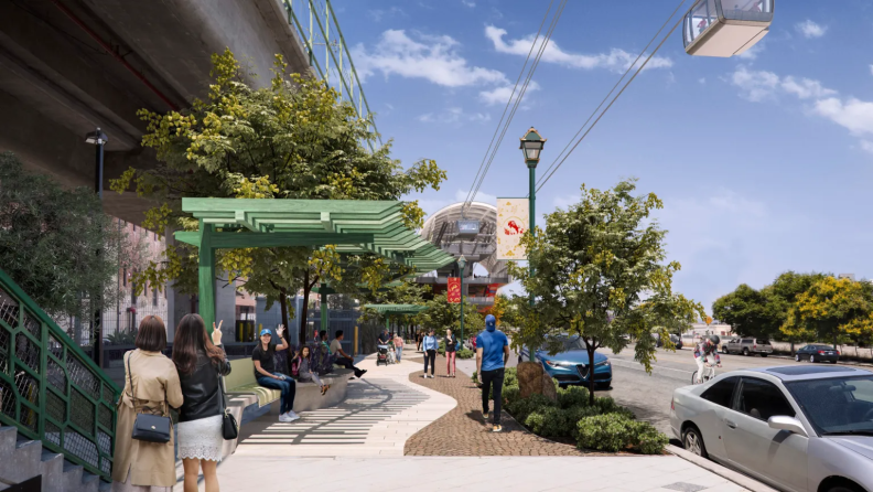 A rendering shows people walking on a street near a station where overhead cables bring a gondola over the street.