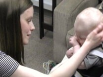 Mother and infant participating in the Still Face Experiment. Mother comforts child after resuming normal interaction with her child.
