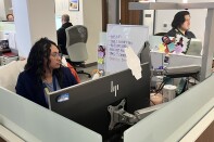  Workers at office cubicles are looking at computer screens, responding to calls for homeless services at the L.A. County Emergency Centralized Response Center. 