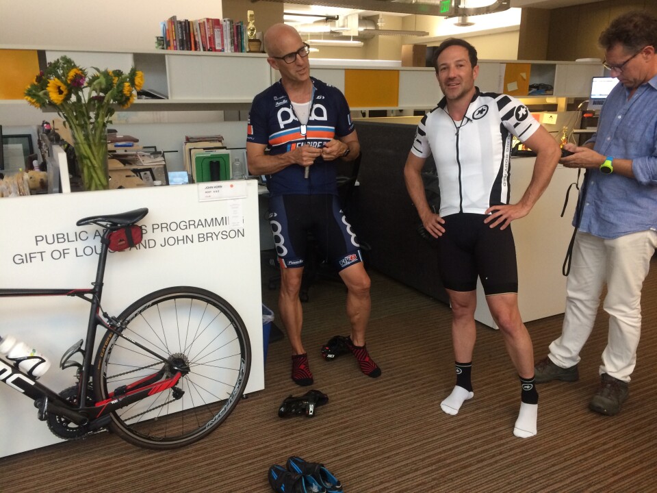 The Frame's John Horn & filmmaker Bryan Fogel get outfitted with audio gear before recording an interview while riding bikes through Pasadena. 