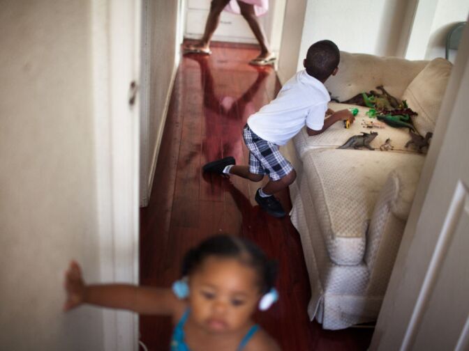 Darniyah Davis,1, and Darryl Jr. Davis, 3 play at their home in Compton, while their mother Harvesha Knight walks by. During the day, Darryl would usually be at Small World, a local pre-school, but a new non-profit took over his school and has not opened its doors yet during this school year.