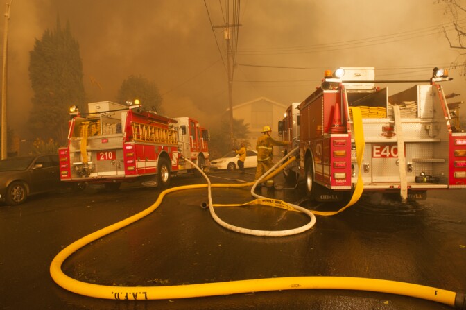 Los Angeles city firefighters try to contain the edge of the Creek Fire as it moves into a neighborhood in Lakeview Terrace on Dec. 5, 2017.