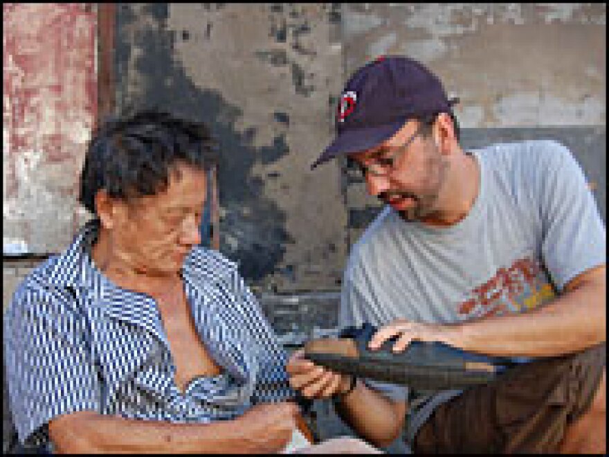 Michael Meyer has a local peddler fix his shoe in DaZhalan, a 600-year-old neighborhood in Beijing.