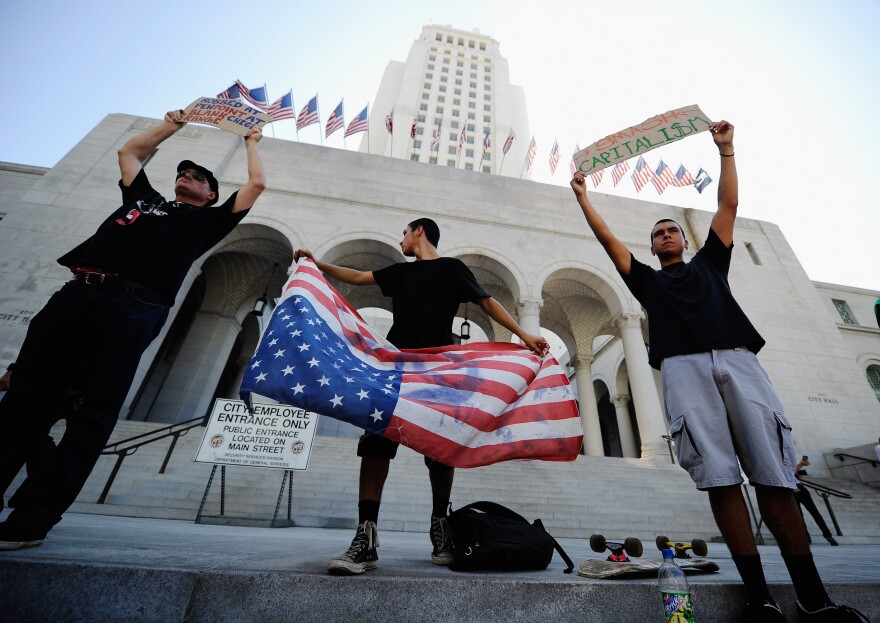 LOS ANGELES, CA - OCTOBER 01:  Protesters hold signs after a march to Los Angeles City Hall during the "Occupy Los Angeles" demonstration in solidarity with the ongoing "Occupy Wall Street" protest in New York City on October 1, 2011 in Los Angeles, California. The protesters slogan, "We are the 99 percent," calls attention to the fact that marchers are not part of the one percent of Americans who hold a vast portion of the nation's wealth.  (Photo by Kevork Djansezian/Getty Images)