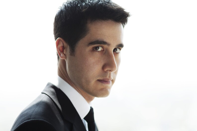 a man in a dark suit stares intently