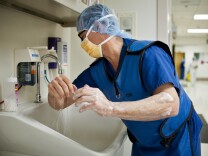 A surgeon scrubs his hands and arms before going into an operating room on Dec. 12, 2013 at Riverside Riverside County Regional Medical Center in Moreno Valley.