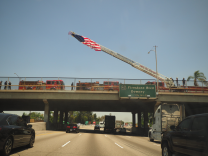Long Beach firefighters wait on overpasses to the 710 Freeway to pay their respects to the procession carrying the body of slain firefighter Dave Rosa