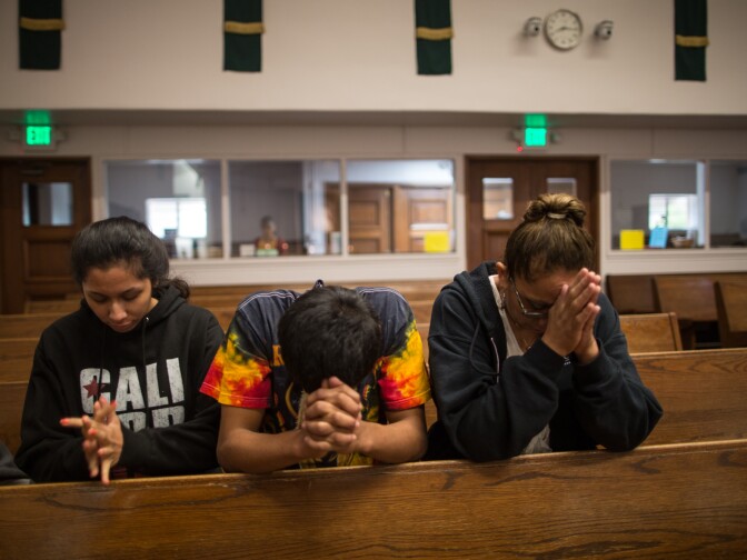 Damian along with his sister and mother pray at a Catholic church in Pomona immediately after his release from six months in juvenile detention camps.