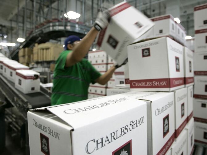 A worker stacks cases of Charles Shaw wine at the Bronco Wine Company facility in Napa, Calif., Tuesday, April 17, 2007. 55,000 cases a day are coming out of this Napa Valley bottling plant, more than some upscale wineries make in a year. And it's owned not by some blue-blooded purveyor of high-end reds but by Fred Franzia, famous for Two Buck Chuck and the ten bucks taboo, as in: No wine is worth more than $10. 
