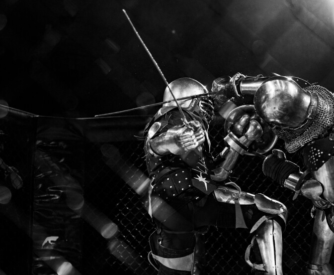 Two armored fighters clash with swords in close combat, one holding a blade near the other's helmet visor.