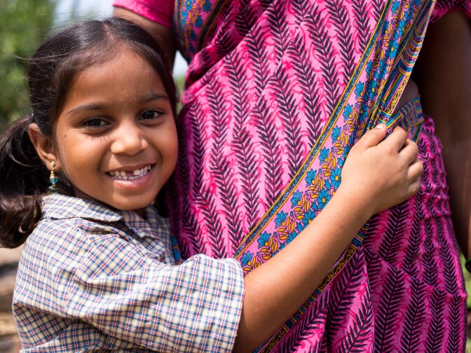 A young child hugs her mother, a former survivor of human trafficking. 