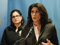 A woman stands at a podium and speaks.