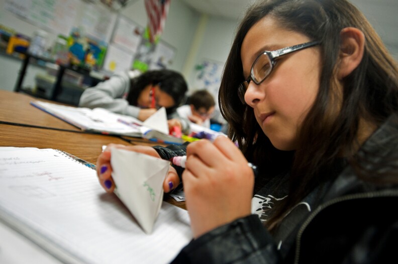 Sixth grader Reyna Ugalde highlights in pink the edges of her handmade polyhedron.