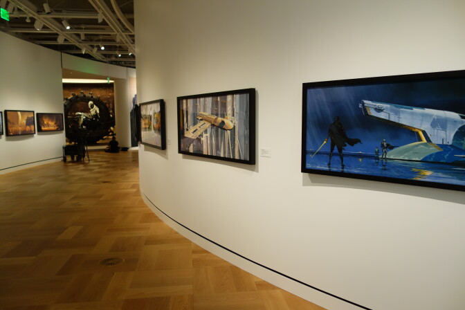 In the foreground, concept art depicting scenes from the Star Wars universe. In the background, props and General Grievous, a character from the Star Wars universe.