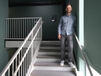 Culver City Council Member Bryan “Bubba” Fish — a man with light skin tone wearing a button–up shirt, chinos and sneakers — stands in the stairwell of his apartment building.