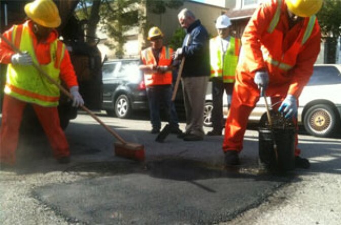 Los Angeles street services crew members Joyce Robinson and Ralph Jackson repair a pothole on Reno Street 