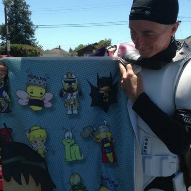 Kevin Doyle holds up a blanket that is part of the chemo bags he will donate to children with cancer