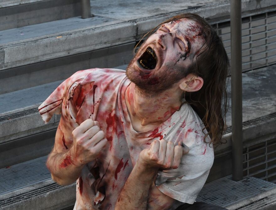 PETA supporters dressed like zombies pretend to gorge themselves on a victim during a protest against consumption of meat in Hollywood, California, on October 26, 2017.