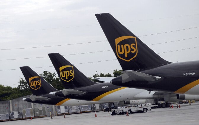 The tails of three UPS aircraft are shown parked at an airport.
