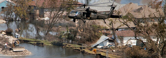 A helicopter lowers sandbags to fill the gap left behind the 17th Street levee failure.