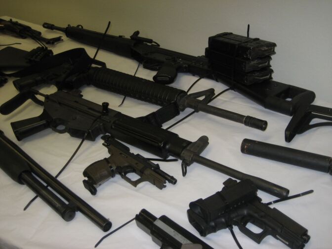 Federal authorities showcase some of the guns seized in a home and warehouse in Bell Gardens.  They accused members of the "Barrio Evil-13" of trafficking large amounts of high powered guns, including AK-47s, Tec-9 sub-machine guns, and handguns equipped with silencers.