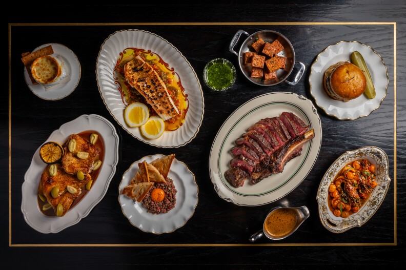 A spread of various French dishes such as like a Paris baguette ham and cheese sandwich, poutine topped with duck meat, cherry duck gravy and gruyère, and ratatouille risotto.
