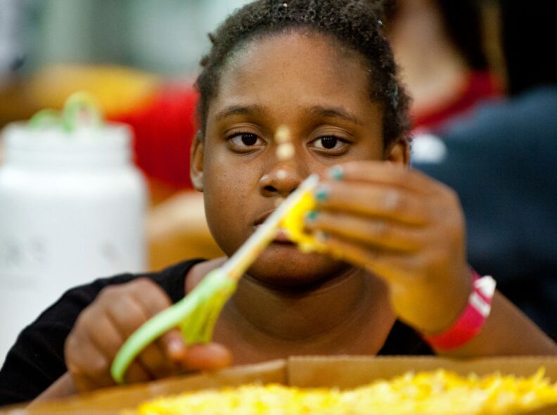 Kekayo Armstrong, 13, cuts up yellow flowers for the City of Hope float. This year's Rose Parade features 41 floats.