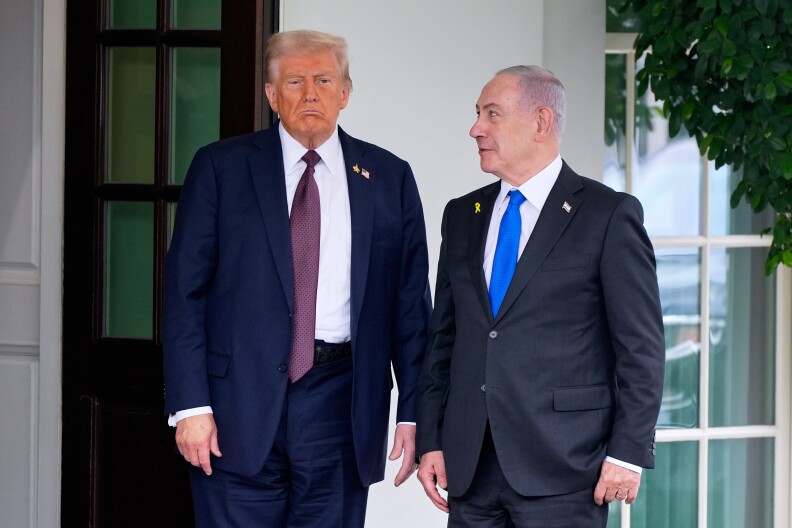 U.S. President Donald Trump stands next to Israeli Prime Minister Benjamin Netanyahu under a portico at the White House.