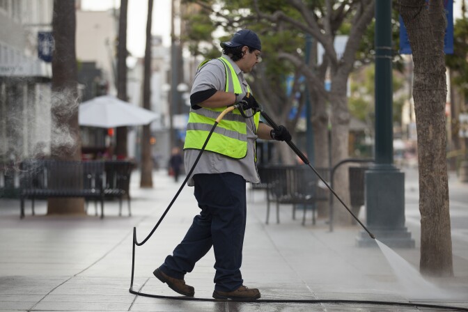 A Santa Monica city employee washes down the Promenade early Tuesday morning, July 15, 2014. The Promenade is pressured washed daily but much of the water is reclaimed and used to water local parks, a maintenance supervisor said.