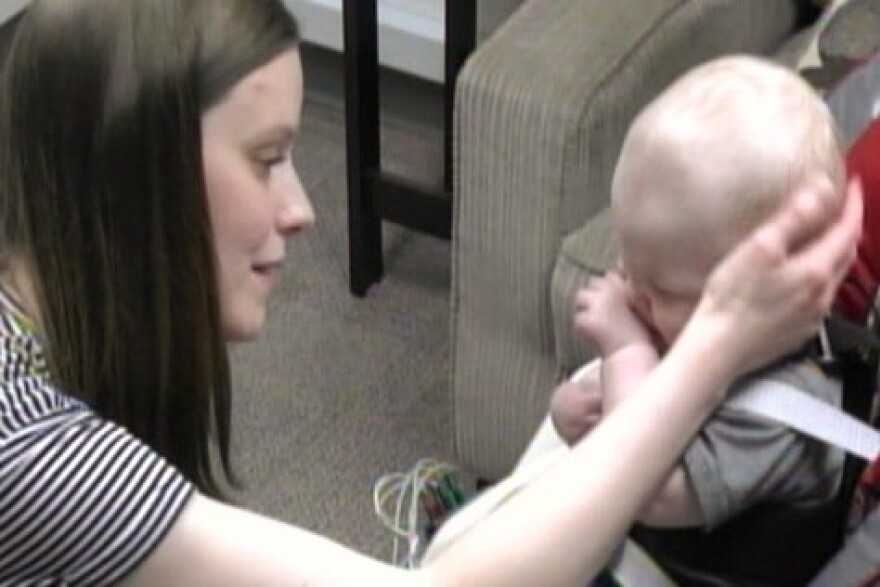 Mother and infant participating in the Still Face Experiment. Mother comforts child after resuming normal interaction with her child.