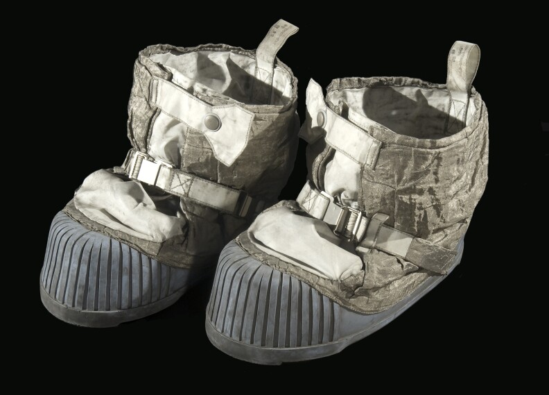 Two moon boots are covered in dust