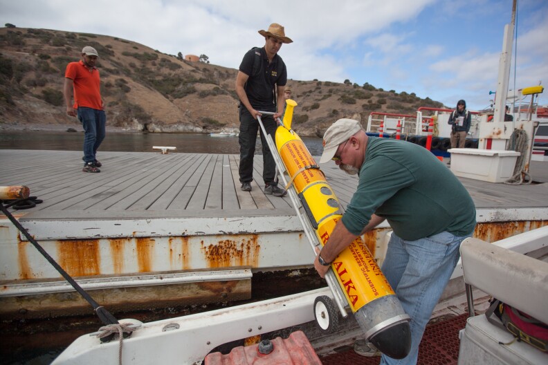 USC researchers load a submersible robot into a skiff in preparation for a two-week mission to monitor ocean water about 100 yards below the surface.