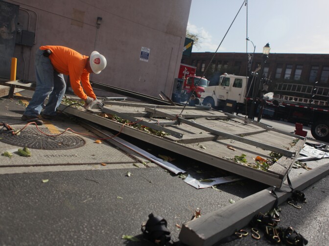 Workers from Clear Channel Outdoor work to clear a sign that had been blown off a building in downtown Pasadena.