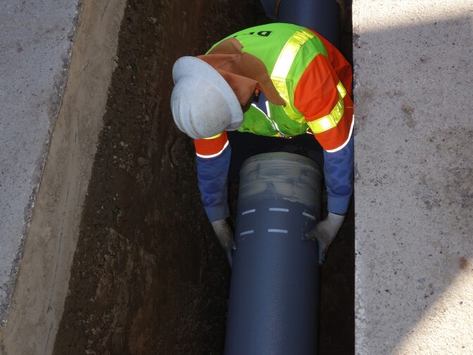 A DWP worker positions the tapered end of a length of earthquake-resistant pipe into the flared bell end of another pipe. The work is on Reseda Blvd. Feb. 11, 2015
