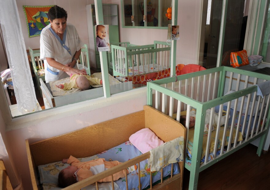 TO GO WITH AFP STORY by Vessela Sergueva.Picture taken on on February 15, 2012,  shows staff member handling a baby at the Saint Ivan Rilski home for medical and social care for children during a visit of United Nations Children's Fund (UNICEF) representatives in Sofia. A practice inherited from communist times, the abandonment of healthy and disabled children by their families is most widespread in the 22 countries of central and eastern Europe, including the former Soviet Union, according to UNICEF mission chief Jean-Claude Legrand.   AFP PHOTO / NIKOLAY DOYCHINOV (Photo credit should read NIKOLAY DOYCHINOV/AFP/Getty Images)