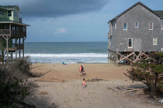 Houses built right at the shoreline of a beach.