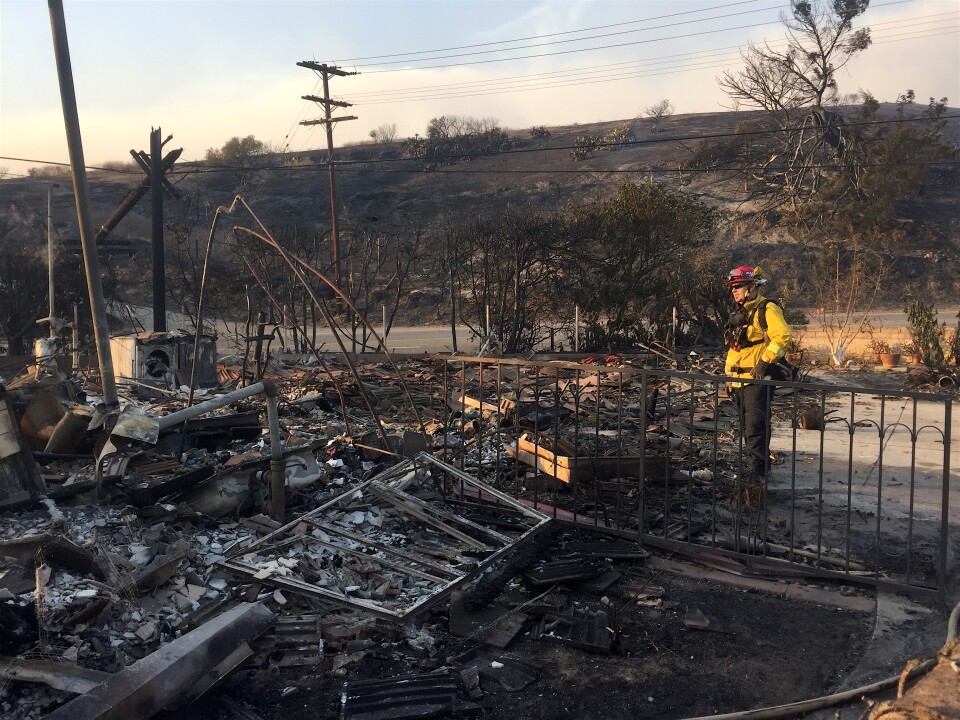 Firefighters stand in the rubble of a home on the corner of Foothill and Day Roads in Ventura. 
