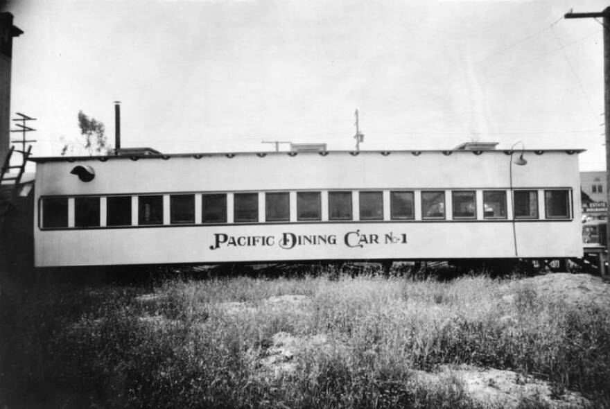 A black and white photo of the railroad car in a field of grass. "Pacific Dining Car No. 1" is painted on the side.