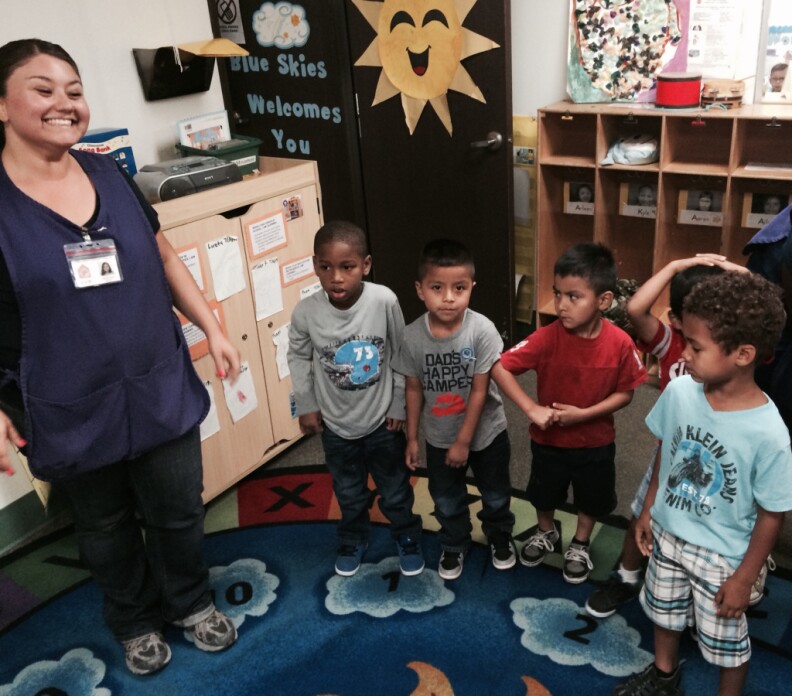 Long Beach preschool teacher, Anabel Lopez, leads children in a round of singing and dancing. Lopez was fearful that she might be laid off due to inconsistent payments by the Department of Education to her organization, Comprehensive Child Development. 