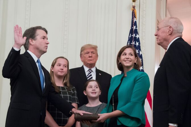 Brett Kavanaugh (L) is sworn-in as Associate Justice of the US Supreme Court by retired Associate Justice Anthony Kennedy (R) before wife Ashley Estes Kavanaugh (2nd-R), daughters Margaret (2nd-L) and Elizabeth (C), and US President Donald Trump on October 8, 2018, at the White House in Washington, DC. (Photo by Jim WATSON / AFP)        (Photo credit should read JIM WATSON/AFP/Getty Images)