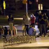 Family and friends wait outside Gateway High School where witnesses were brought for questioning after a shooting at a movie theater showing the Batman movie "The Dark Knight Rises," Friday, July 20, 2012 in Aurora, Colo.  A gunman wearing a gas mask set off an unknown gas and fired into the crowded movie theater killing 12 people and injuring at least 50 others, authorities said. (AP Photo/Barry Gutierrez)