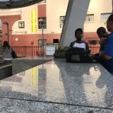 Julian Turner (right), part of Metro's homeless outreach team, chats with two young men outside the Pershing Square stop.