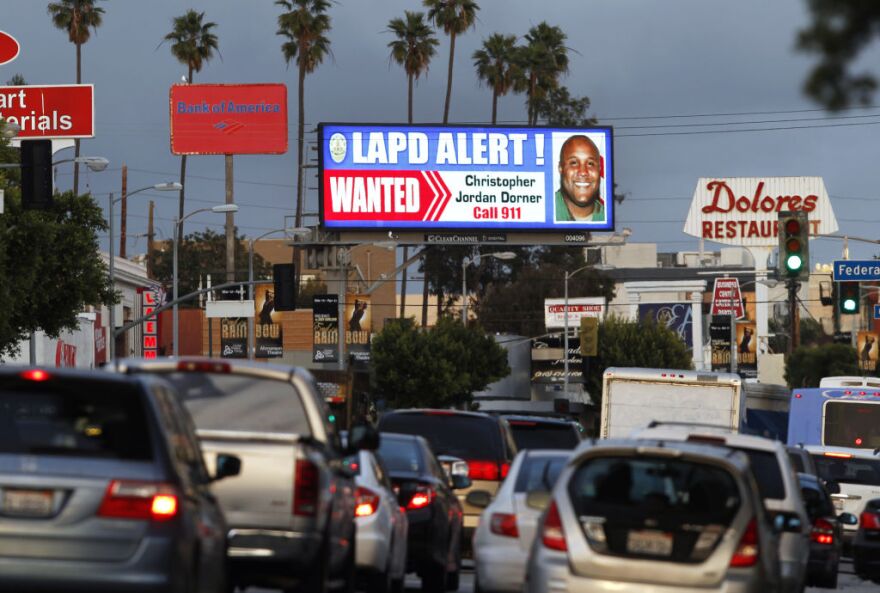 A digital billboard along Santa Monica Boulevard on the west side of Los Angeles shows a "wanted" alert for former Los Angeles police officer Christopher Dorner Friday, Feb. 8, 2013.  Dorner is suspected in a spree of violence as part of a vendetta against law enforcement after being fired by the department. He is also a suspect in the shooting deaths of a former LAPD captain's daughter and her fiance, and two other shootings that left an officer dead and two others wounded.