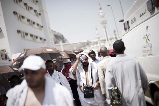 Muslim pilgrims walk past Saudi ambulances carrying injured pilgrims at an emergency hospital in Mina, near the holy city of Mecca, on the first day of Eid al-Adha on September 24, 2015, following a stampede that left at least 717 pilgrims dead and hundreds wounded. The stampede, the second deadly accident to strike the pilgrims this year, broke out during the symbolic stoning of the devil ritual, the Saudi civil defence service said. AFP PHOTO/MOHAMMED AL-SHAIKH        (Photo credit should read MOHAMMED AL-SHAIKH/AFP/Getty Images)