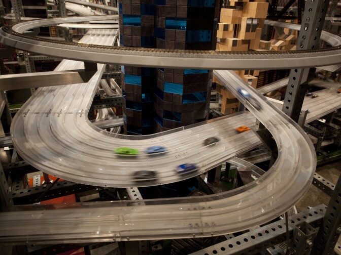 Cars speed along the tracks of Metropolis. The sculpture breaks into nine pieces for transport.