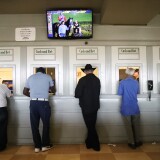 ARCADIA, CALIFORNIA - JUNE 23:  Gamblers stand at betting windows on the final day of the winter/spring horse racing season at Santa Anita Park on June 23, 2019 in Arcadia, California. Santa Anita ownership banned a Hall of Fame trainer yesterday following the death of a fourth horse from his stable at the track. It was the 30th race horse to die at the famed racetrack since December 26. (Photo by Mario Tama/Getty Images)