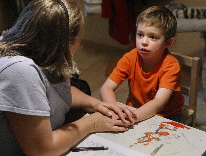 Therapist Laurie Waguespack holds Grant Fulton's hands and looks him square in the eyes to gain his full attention in Lacey, Wash., Thursday, Aug. 14, 2008. Her goal is to help the Grant, who has autism, improve his social and communication skills.