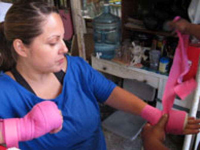Boxing mom and Cal State L.A. grad Frances Calderon gets her fists taped up.