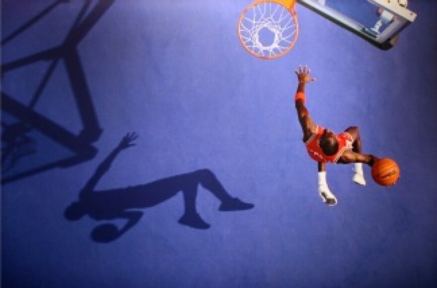 A young Michael Jordan soars through the air on his way to the basket.